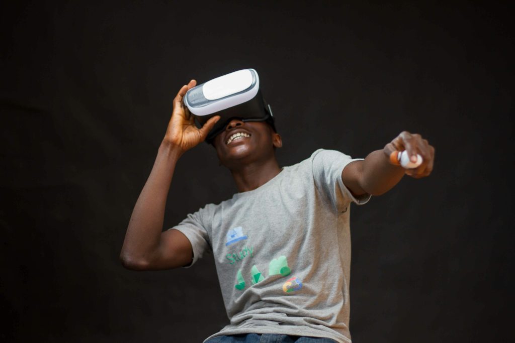 A young black man enjoying virtual reality with a headset, indoors.